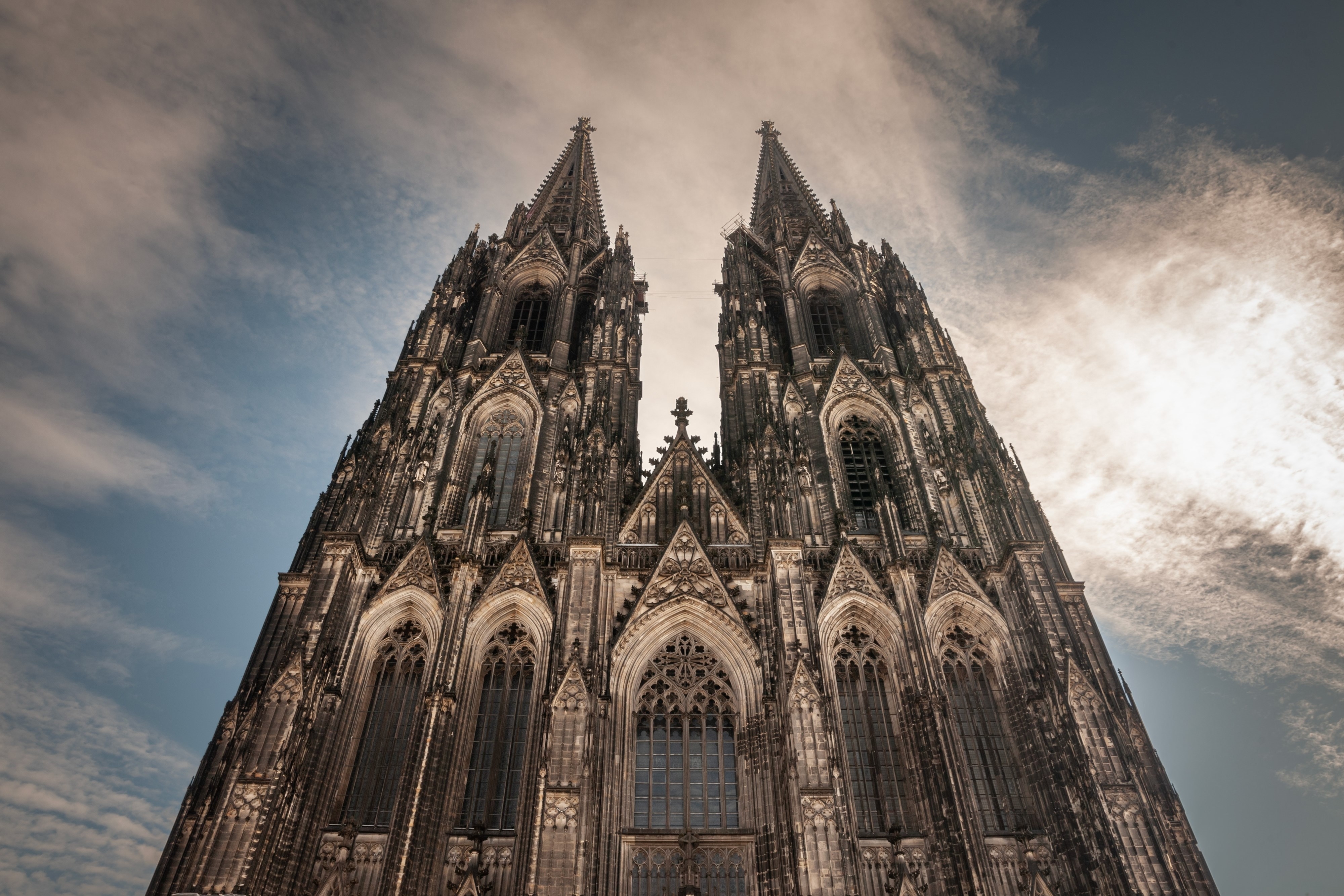 Cologne Cathedral seen from below with blue sky. Cologne Cathedral, or Kolner Dom, is the main landmark of Cologne and a catholic church in Germany.