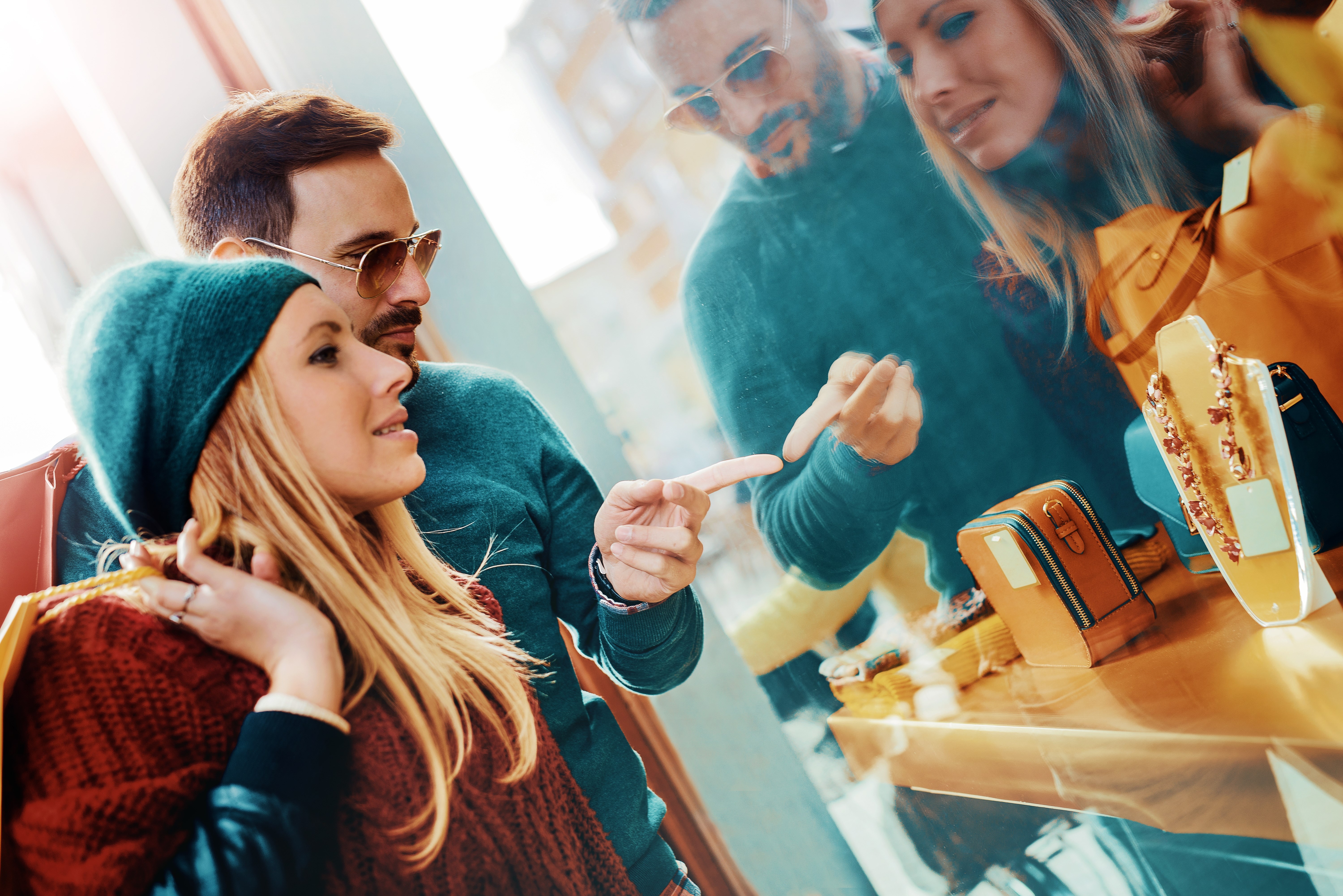 Young couple carrying shopping bags on shoulders and enjoying together in the city. Consumerism, shopping and lifestyle concept
