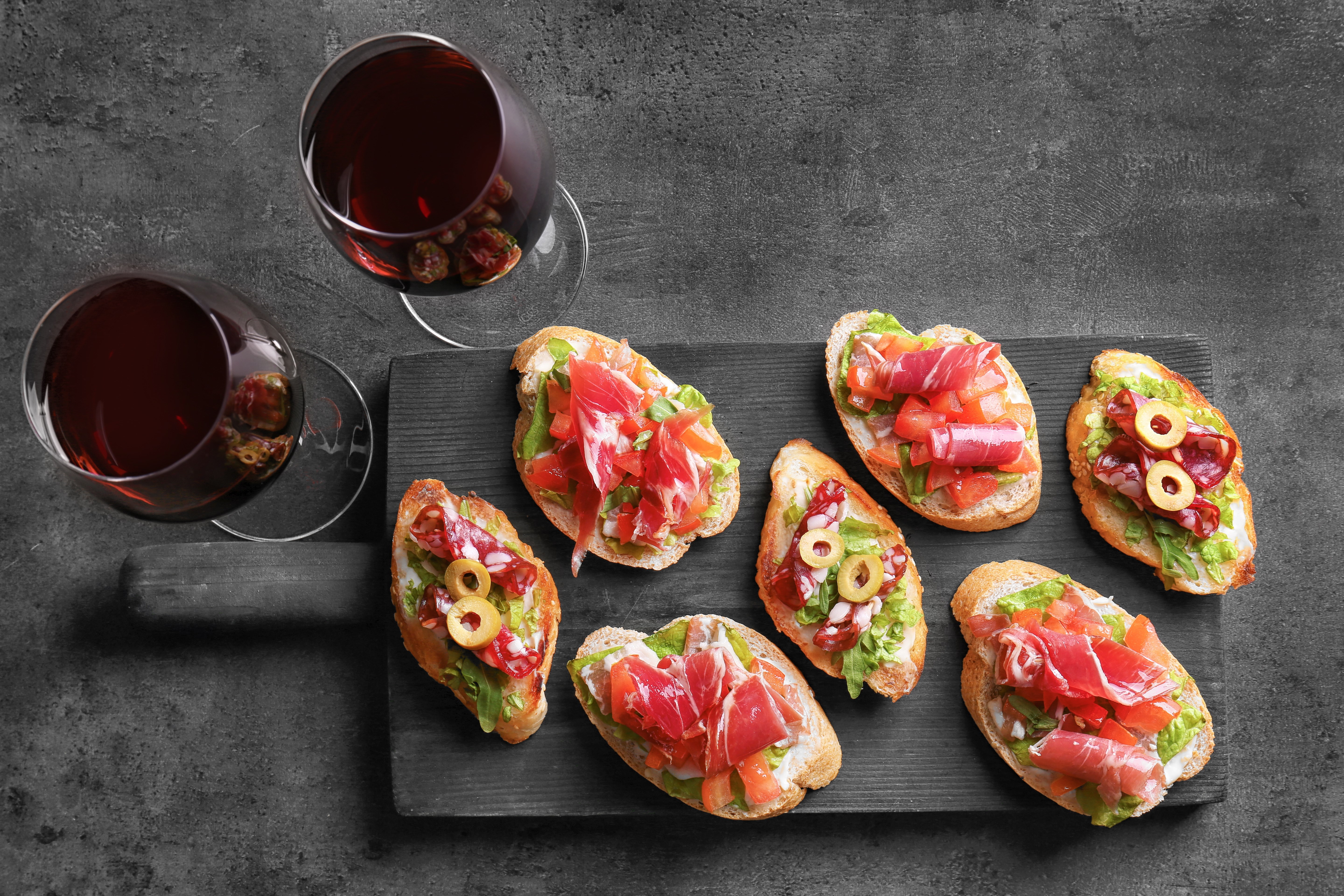Tasty bruschetta served with wine on gray  background