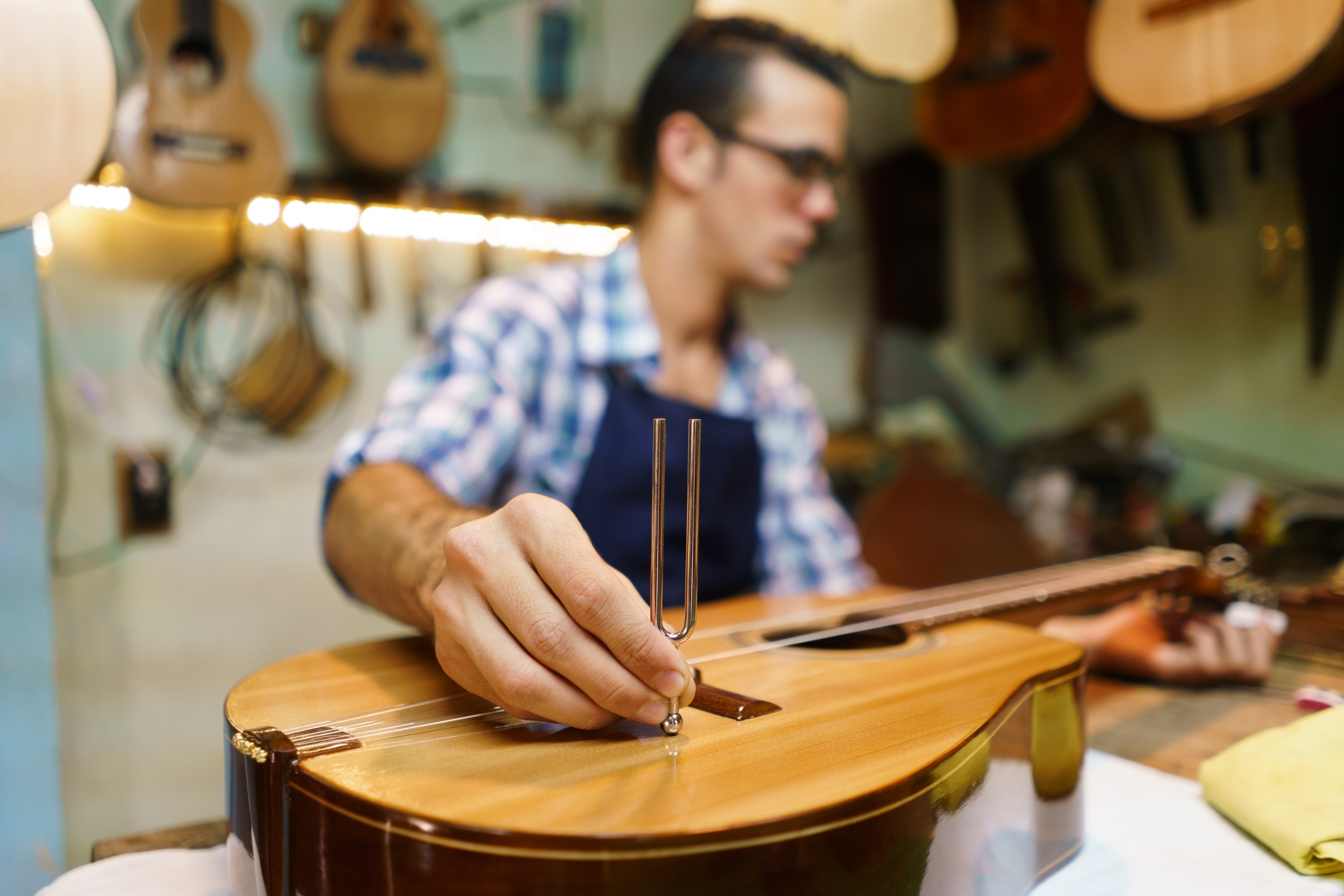String instrument shop with employee fixing a guitar