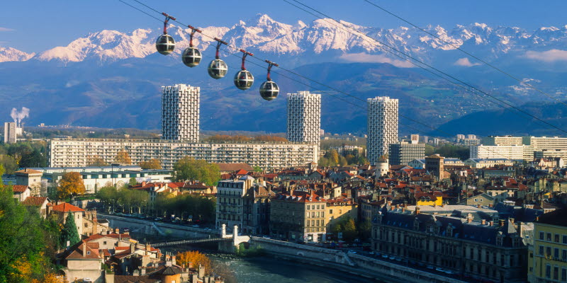 City of Grenoble with a river, houses and alps in the background City of Grenoble with a river, houses and alps in the background