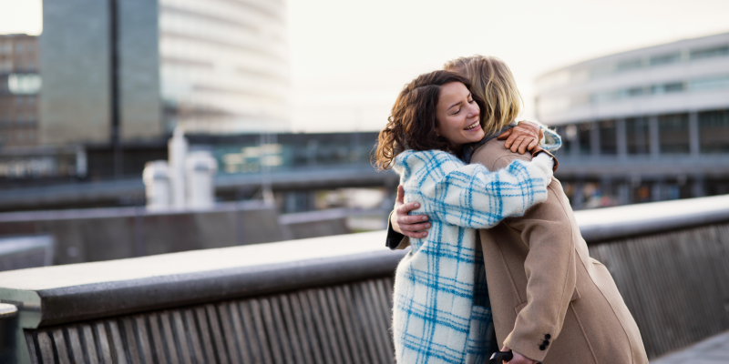Two persons hug outside the terminal. Two persons hug outside the terminal.