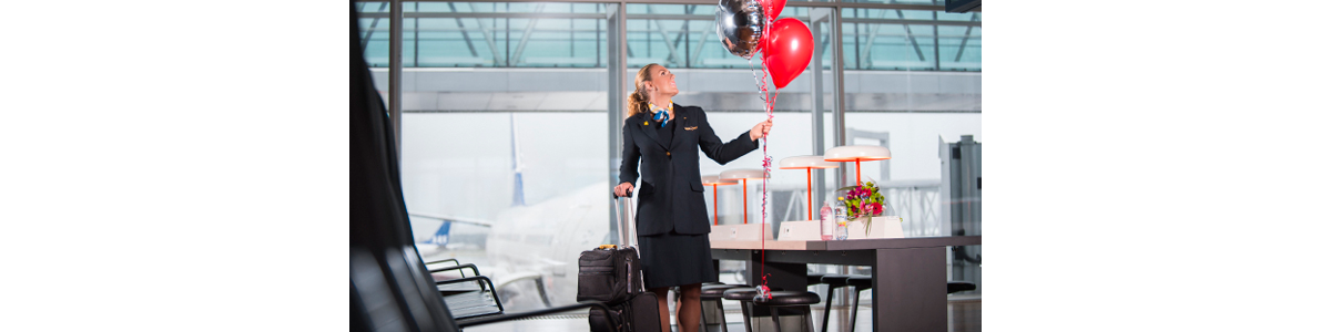 A flight attendant with suitcases and balloons A flight attendant with suitcases and balloons