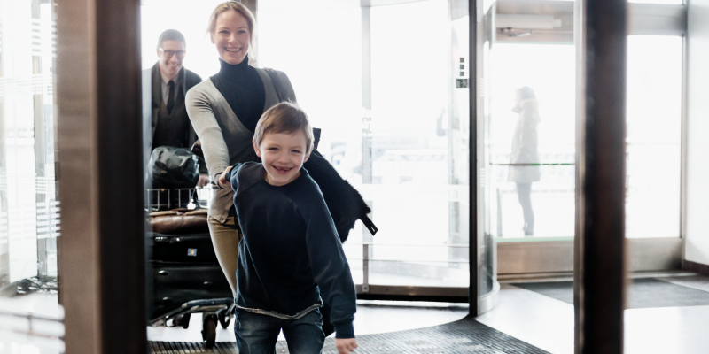 Boy holding woman's hand at the entry of a terminal at Stockholm Arlanda Boy holding woman's hand at the entry of a terminal at Stockholm Arlanda