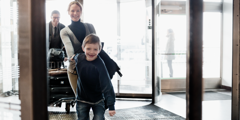 Boy holding woman's hand at the entry of a terminal at Stockholm Arlanda Boy holding woman's hand at the entry of a terminal at Stockholm Arlanda