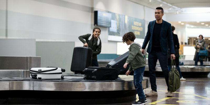 A man och two children at a baggage carousel A man och two children at a baggage carousel