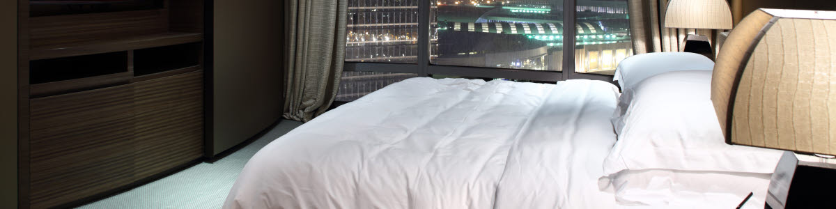 Hotel room with a bed and a view over a city Hotel room with a bed and a view over a city