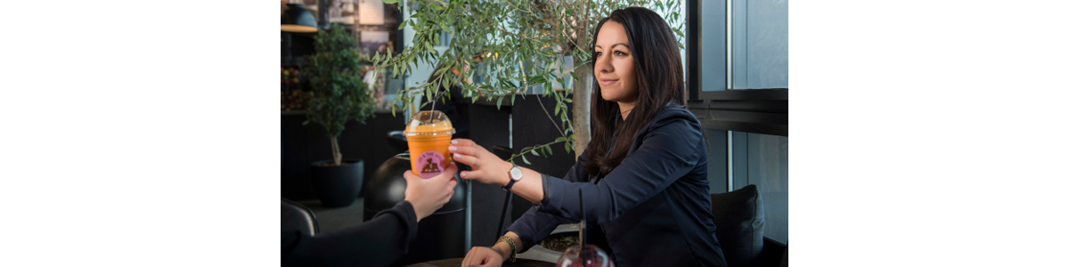 A woman receiving a plastic cup with juice A woman receiving a plastic cup with juice