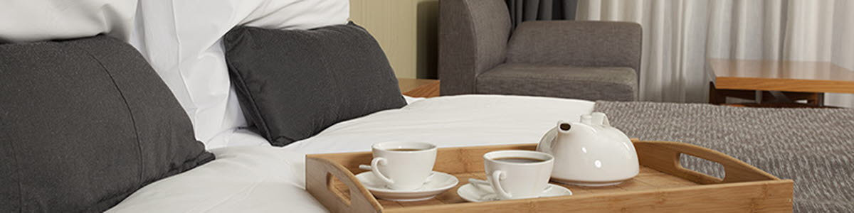 Hotel suite with coffee tray on bed Hotel suite with coffee tray on bed