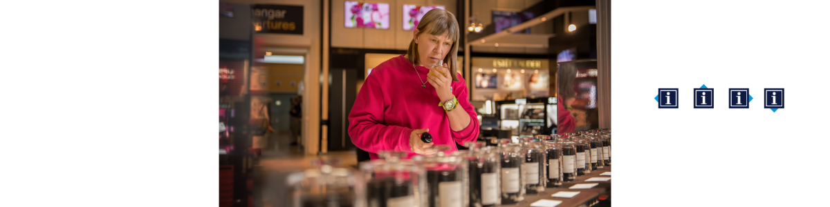 A woman in a pink sweater trying a perfume in a shop A woman in a pink sweater trying a perfume in a shop