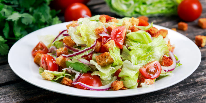 White plate with salad and tomatoes White plate with salad and tomatoes