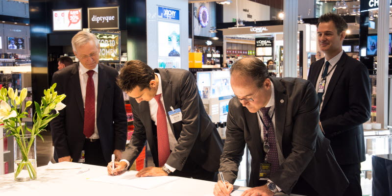 Two men signing the contract with Dufry Two men signing the contract with Dufry