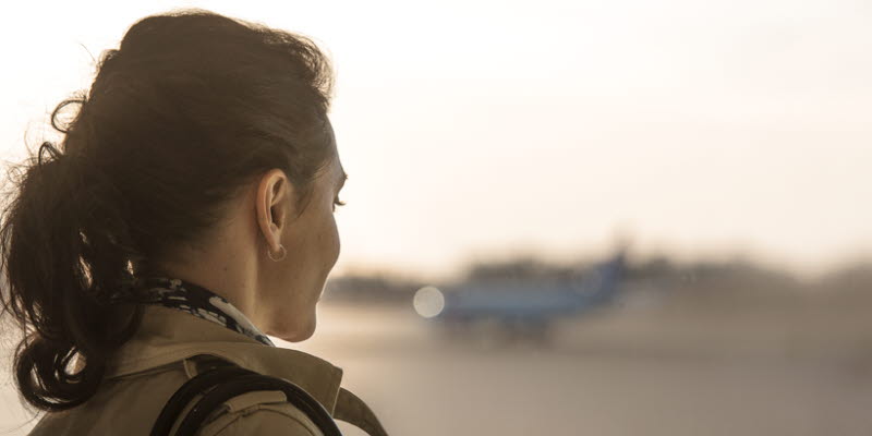 A woman looking out a window at an airplaine A woman looking out a window at an airplaine