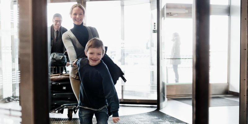 Boy holding woman's hand at the entry of a terminal at Stockholm Arlanda Boy holding woman's hand at the entry of a terminal at Stockholm Arlanda