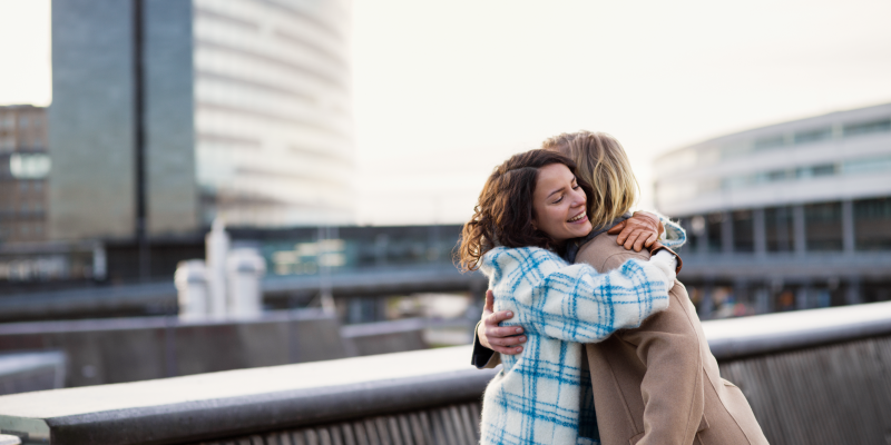Two persons hug outside the terminal. Two persons hug outside the terminal.